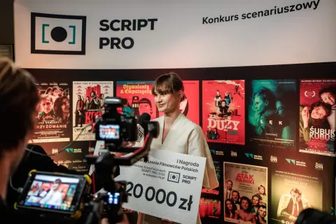 Kobieta z nagrodą 20 000 zł na tle plakatów filmowych. To może być początek prawdziwej historii kradzieży scenariusza do najbardziej oczekiwanego filmu roku.