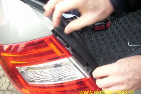 Wymiana żarówki w tyle Seat Ibiza. Dłonie demontują element lampy, przygotowując do wymiany.