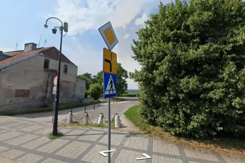 Znak pierwszeństwo łamane kierunkowskaz informuje o skręcie w prawo i ustąpieniu pierwszeństwa. Obok znak przejścia dla pieszych.