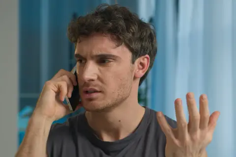 Mężczyzna rozmawia przez telefon, wyrażając frustrację.
