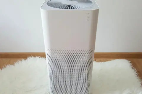Biały oczyszczacz powietrza na puszystym dywanie, zapewniający świeże i czyste powietrze w domu.