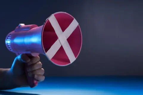 Różowy megafon z taśmą krzyżującą na wylocie, symbolizujący shadowban i niemożność wyrażenia głosu.