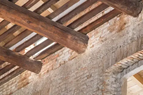 Trave in legno deteriorate e mattoni a vista: segnali evidenti per capire se un tetto è da rifare.