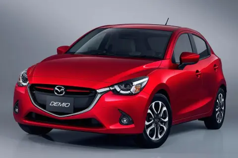 Czerwona Mazda Demio z eleganckim przodem i charakterystycznym grillem.