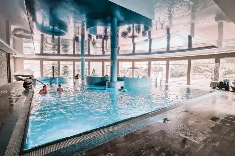 Relaks w basenie hotelu Tristan. Dzieci pluskają się w wodzie, a dorośli odpoczywają przy basenie.