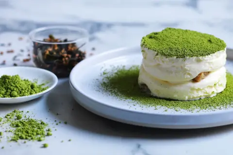 Dolci veloci al matcha: soffice crema e polvere verde brillante su un piatto, con ingredienti a lato.