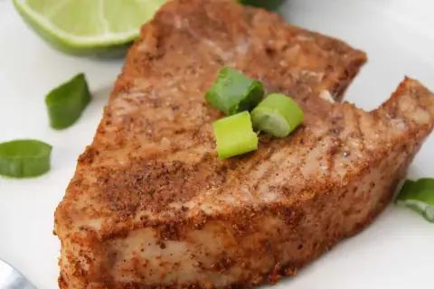 En saftig bit tonfisk, kryddad och perfekt tillagad. Serverad med lime och salladslök för en fräsch touch.