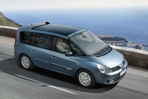 Niebieski Renault Espace 4 z panoramicznym dachem jedzie malowniczą trasą nad morzem.
