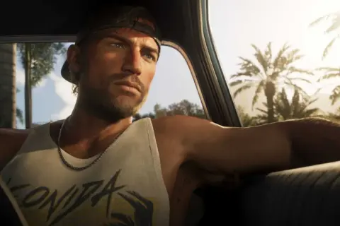 Jason z GTA 6 w czapce i podkoszulku jedzie samochodem przez słoneczne miasto z palmami.