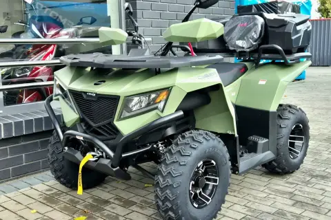 Zielony quad z bagażnikami, idealny na kategorię B. Wygląda na solidną maszynę do jazdy terenowej.
