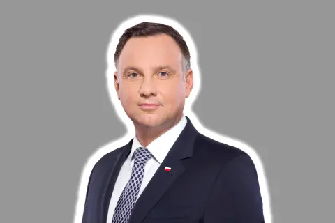 Prezydent Andrzej Duda w garniturze, z biało-czerwoną flagą na klapie. Jego twarz wyraża powagę, jakby rozważał kwestię ułaskawienia.