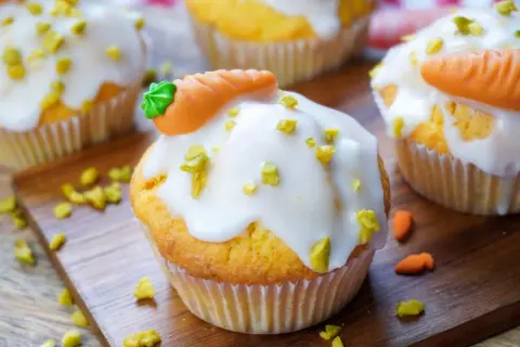 Leckere, schnelle Muffins mit weißer Glasur und kleinen Marzipan-Karotten. Perfekt für den Osterbrunch!
