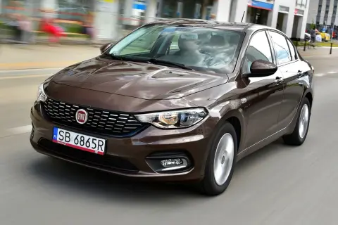 Brązowy fiat tipo sedan w ruchu miejskim.