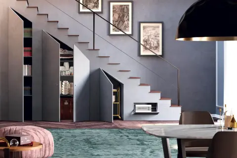 Soluzione intelligente per chiudere una nicchia nel muro sotto le scale, creando spazio contenitivo per libri, stoviglie e altro.