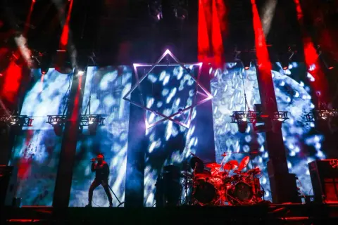 Wokalista na scenie, perkusja, wielka gwiazda na tle ekranu. Niesamowita atmosfera na **impact festival**.