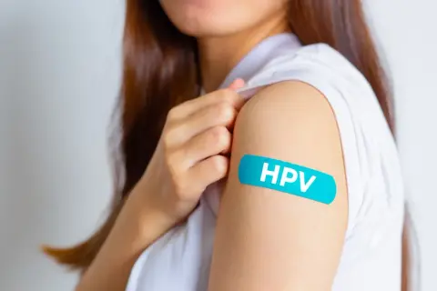Ramię z plastrem z napisem HPV. Dostępność szczepionki HPV i refundacja to ważna kwestia dla zdrowia.