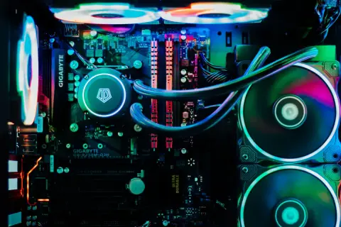 Wnętrze komputera z podświetleniem RGB. Widoczny system chłodzenia wodnego i wentylatory, które zapewniają efektywne chłodzenie.