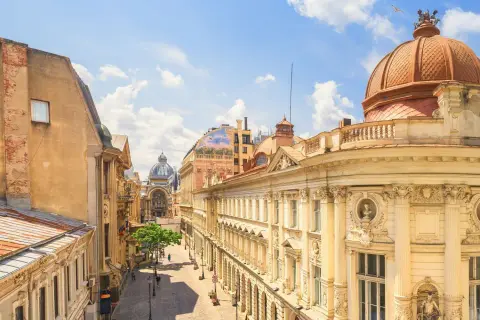 Ulica z zabytkowymi kamienicami i kopułą, idealna na tani city break.