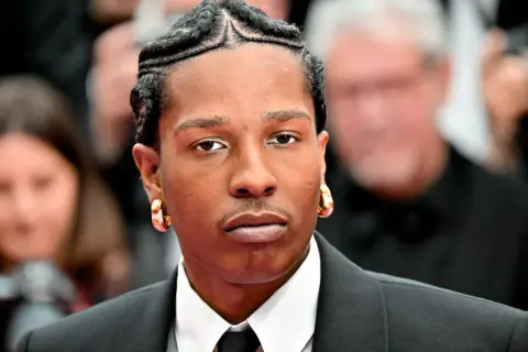A$AP Rocky z warkoczykami i złotymi kolczykami, gwiazda, która mogłaby pojawić się na CLOUT FESTIVAL LINEUP.
