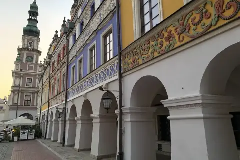 Zamość co zobaczyć: kolorowe kamienice z arkadami i wieża ratuszowa tworzą malowniczy widok.