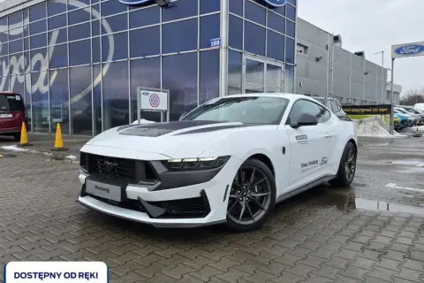 Biały Ford Mustang przed salonem Ford. Sprawdź aktualną mustang cena i dostępność od ręki.