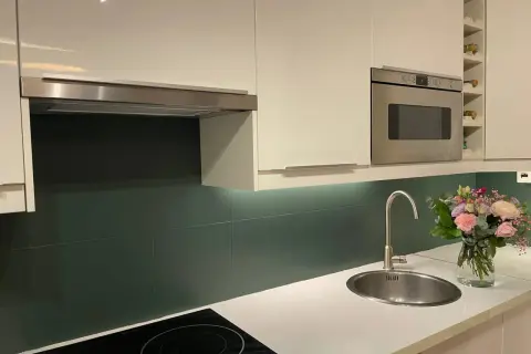 Crédence cuisine vert foncé, une idée pour quelle peinture pour carrelage mural cuisine ? Évier, hotte, four, bouquet de fleurs.