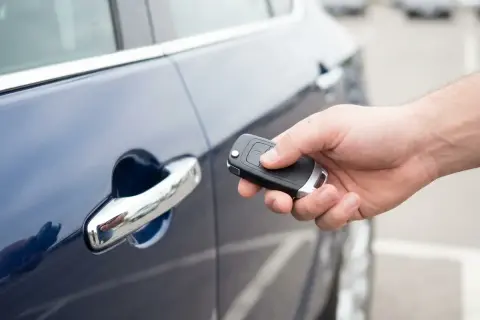 Dłoń trzyma kluczyk do samochodu, gotowa do użycia funkcji keyless go.