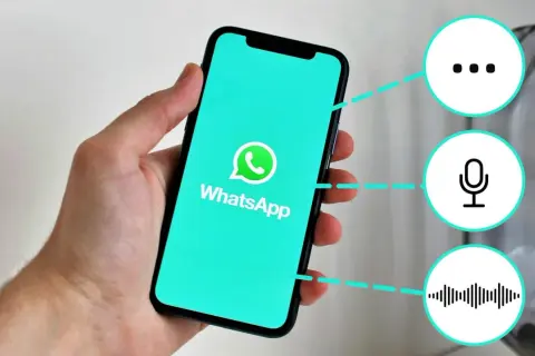 Mano sostiene un teléfono con WhatsApp. Iconos de puntos suspensivos, micrófono y onda sonora sugieren funciones, como "que significa gn en inglés".