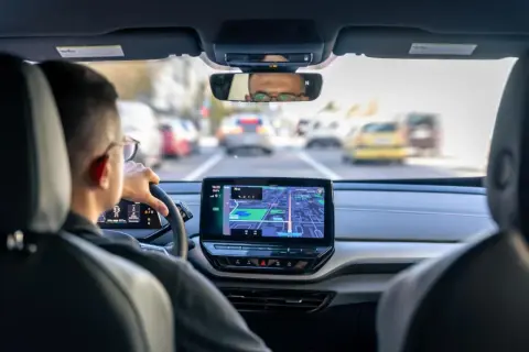 Navigazione con Android Auto Wireless su un'auto moderna. Il conducente segue il percorso sullo schermo centrale, godendosi la comodità senza fili.