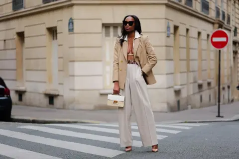 Eine Frau in beiger Marlenehose und Blazer, die einen stilvollen Look kreiert.