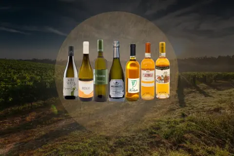 Selezione di bottiglie di vino bianco friulano, tra cui Sauvignon, Chardonnay e Prosecco, su uno sfondo di vigneti al tramonto.
