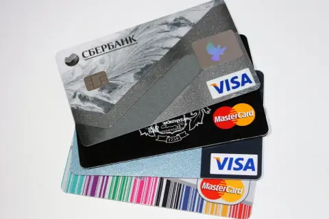 Pile di carte di credito e prepagate, tra cui Visa e Mastercard. L'IBAN è visibile su alcune carte.