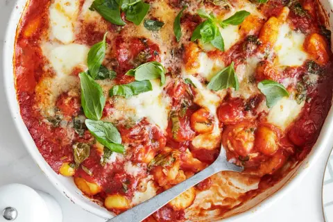 En ugnsbakad gnocchi alla sorrentina med smält mozzarella och färsk basilika.