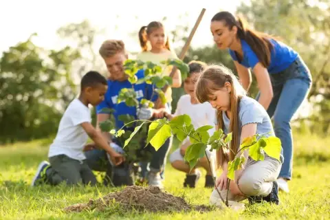 Kinder pflanzen Bäume im Rahmen eines Projekts zum Umweltschutz im Kindergarten.