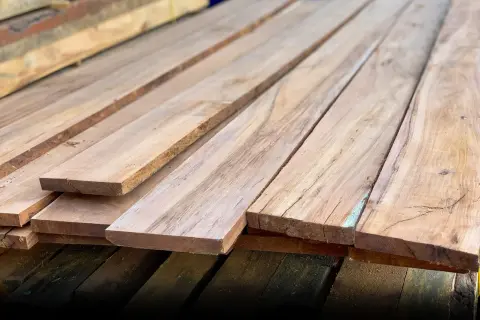 Tablones de madera compuesta apilados, listos para ser transformados en muebles o estructuras.