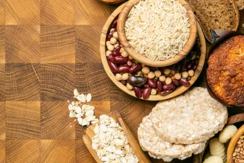 Varietà di alimenti: riso, fagioli, avena, muffin, gallette di riso, pasta e pane. Alcuni sono carboidrati raffinati quali sono, altri integrali.