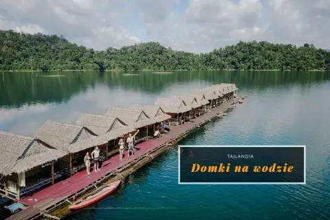 Domki na wodzie w Khao Sok, Tajlandia. Grupa ludzi relaksuje się na drewnianym pomoście, otoczonym bujną zielenią i spokojną wodą.