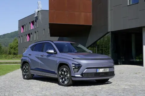 Le plus petit SUV, un véhicule gris moderne, se gare devant un bâtiment architectural audacieux.