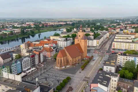Gorzów Wielkopolski atrakcje dla dzieci: malowniczy widok na miasto z rzeką, kościołem i kolorowymi kamienicami. Idealne miejsce na rodzinne wycieczki.