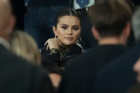 Selena Gomez w czarnej kurtce i bluzce w panterkę, z dłonią opartą o policzek. Fani spekulują o jej ciąży.