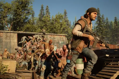 W grze Days Gone czas gry to walka o przetrwanie. Deacon z karabinem mierzy w hordę zombie wydostającą się z wagonu.