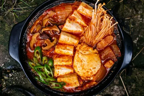 Pikantne kimchi jjigae z tofu, grzybami i zieloną papryczką. Idealny przepis na rozgrzewający posiłek.