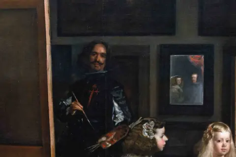 A painter, brush in hand, stands before a canvas, surrounded by royalty. This famous art from the Baroque period captures a moment of creation.