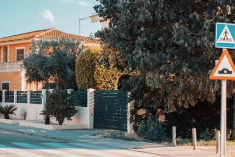 Panneau de passage piétons et ralentisseur. La question "un particulier peut-il filmer la voie publique" se pose devant cette maison.