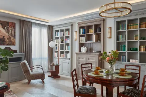 Elegancki salon z biblioteczkami, jadalnią i wygodnym fotelem. Klasyczny styl dekoracji wnętrz.