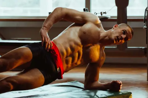 Ein Mann trainiert seine seitliche Bauchmuskulatur in einem Fitnessstudio.