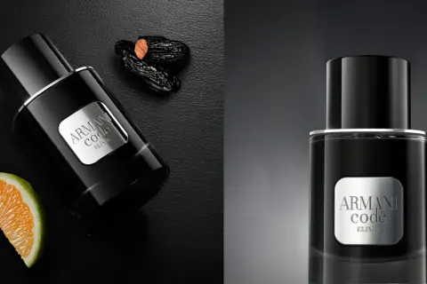 Eleganckie perfumy męskie Armani Code Elixir w czarnej butelce, obok pomarańczy i daktyli.