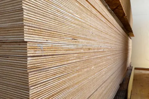 Una pila de maderas blancas, con sus finas capas visibles, listas para ser transformadas en muebles o estructuras.