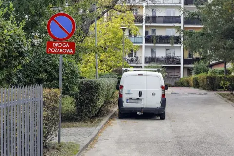 Znak "zakaz zatrzymywania się" na drodze pożarowej. Kierowca białego vana może otrzymać mandat zgodnie z art. 97 k.w. w zw. z art. 47 p.r.d.