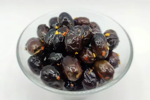 Olive nere sotto sale, un classico della ricetta marchigiana, in una ciotola di vetro.